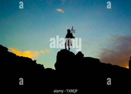 Silhouette Scottish Piper vêtu d'un kilt, debout sur un rocher jouant les cornemuses dans le désert islandais pendant la course Fire and Ice Ultra. Banque D'Images