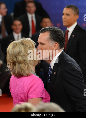 Candidat républicain Mitt Romney embrasse sa femme, Ann, avec le président américain Barack Obama debout dans l'arrière-plan à l'issue de la deuxième élection présidentielle, débat style Mairie, à l'Université Hofstra, le 16 octobre 2012 à Hempstead, New York. UPI/Pat Benic Banque D'Images