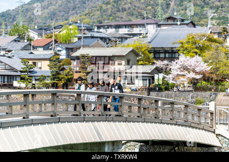 Uji, JAPON - 14 Avril 2019 : River au début du printemps dans un village avec vue sur les maisons de ville et de personnes marchant sur pont et cherry bl Banque D'Images