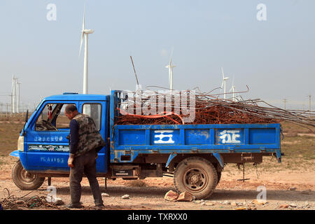 Un Chinois recueille des métaux recyclables en plastique et il a trouvé près de l'exploitation massive des éoliennes dans la zone de développement dans Taiyangshan Wuzhong, une ville frontière dans la province du nord-ouest de la région autonome du Ningxia Hui le 22 septembre 2011. Les 215 milles carrés de zone a les avantages de l'énergie éolienne et solaire forte, résultant en 300 mégawatts d'énergie éolienne et 100 MW d'énergie photovoltaïque. Taiyangshan est la plus grande base de l'énergie propre en Chine. UPI/Stephen Shaver Banque D'Images
