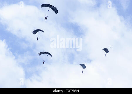 Les parachutistes militaires parachutistes également appelé dans le ciel avec de nombreux nuages. Banque D'Images
