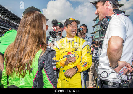 Helio Castroneves commence à célébrer après avoir le jour un temps rapide de Indy 500 Qualifications que Danica Patrick (à gauche) et Tim Cindric Penske Manager sur regarder, à l'Indianapolis Motor Speedway le 19 mai 2018 à Indianapolis, Indiana. Photo par Edwin Locke/UPI Banque D'Images