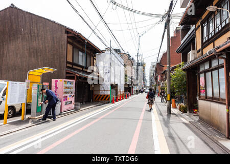 Kyoto, Japon - 17 Avril 2019 : City street dans le centre-ville avec l'homme l'achat de distributeur automatique et à la population locale, randonnée pédestre Banque D'Images