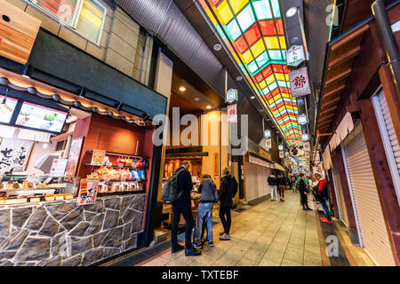 Kyoto, Japon - 17 Avril 2019 : avec les gens de la ville dans shopping arcade marché Nishiki couverts boutiques restaurants et les vendeurs d'aliments Banque D'Images