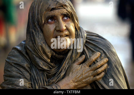 Une femme musulmane chiite iranien couvert de boue, prie au cours d'une cérémonie religieuse traditionnelle en Khoramâbâd, une ville dans la province du Lorestan, 499 km (310 milles) à l'ouest de Téhéran, Iran le 19 janvier 2008. Achoura est le pic de dix jours de deuil pendant le mois de Muharram islamique, le premier mois du calendrier lunaire, lorsque les musulmans chiites pleurent le massacre de l'Imam Hussein il y a 1366 ans dans ce qui est maintenant Karbala dans le sud de l'Iraq. Mélanger l'eau de rose avec Deuil la criblée d'argile dans une zone de 12 mètres carrés. Ils battre doucement sur leurs épaules avec des chaînes alors que la tête et les épaules ont été couverts Banque D'Images