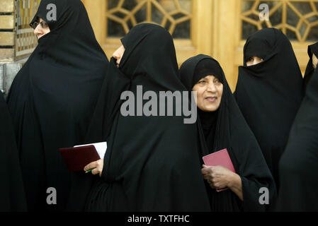 Les femmes iraniennes détiennent leur certificat, tels qu'ils sont en ligne avant l'exercice de leur droit de vote dans les élections parlementaires de l'Iran à un bureau de scrutin à l'Saint Masoumeh de culte dans la ville sainte de Qom, à 80 milles (130 kilomètres) au sud de Téhéran, Iran le 14 mars 2008. (Photo d'UPI/Mohammad Kheirkhah) Banque D'Images