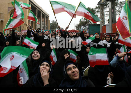 Les filles de l'école iranienne drapeaux iraniens de l'onde au cours d'une cérémonie pour souligner l'anniversaire de la révolution islamique à l'Behesht-e Zahra Zahra's paradise (cimetière) dans le sud de Téhéran, Iran, le 1 février 2010. La célébration est de marquer le retour de l'Ayatollah Khomeini 1979 de l'exil. Maryam Rahmanian/UPI Banque D'Images