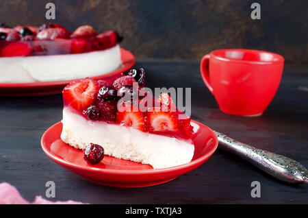 Gâteau mousse à la crème de fruits avec la gelée et les baies fraîches sur la table rustique foncé de délicieux petits fruits rouges frais. La confiture. La vaseline. Le gâteau au fromage. Banque D'Images