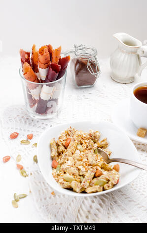 Plusieurs types de céréales de céréales avec écrous,Chips de noix de coco et fruits secs en plaque blanche pour le petit-déjeuner, de copier l'espace, alimentation saine notion Banque D'Images