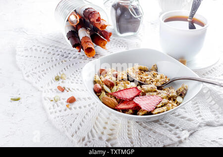 Plusieurs types de céréales de céréales avec écrous,Chips de noix de coco et fruits secs en plaque blanche pour le petit-déjeuner, de copier l'espace, alimentation saine notion Banque D'Images