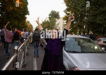 Un supporter de l'Iran le président nouvellement élu, Hassan Rohani est joyeuse alors qu'elle prend part à une célébration de la rue après le ministère iranien de l'intérieur a annoncé sa victoire électorale, Téhéran, Iran, le 15 juin 2013. Le candidat réformiste et modéré Rohani évité un run-off en obtenant plus de 51  % des voix. Maryam Rahmanian/UPI Banque D'Images