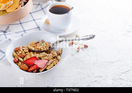 Plusieurs types de céréales de céréales avec écrous,Chips de noix de coco et fruits secs en plaque blanche pour le petit-déjeuner, de copier l'espace, alimentation saine notion Banque D'Images