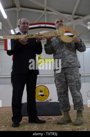 Le Brigadier-général David Quantock (R) des mains du ministre de la Justice irakien Dara Nur al-Din une clé en bois symbolique à la prison de Taji, un 107 millions de dollars composé qui peut contenir jusqu'à 5 600 détenus et est située à environ 25 kilomètres (15 milles) au nord de Bagdad, lors d'une cérémonie de transfert de contrôle de l'un des deux autres nous' de détention pour les autorités irakiennes le 15 mars 2010. UPI/Ali Jasim Banque D'Images
