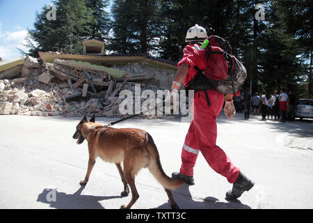 Forces de secours avec des chiens de détection recherche de victimes sous les décombres à Amatrice dans la province de Rieti, Italie, 25 août 2016.. Les travailleurs continuent de rechercher des victimes que les répliques du séisme a frappé la région le 25 août 2016. Photo par Marco D'Antonio/ UPI Banque D'Images