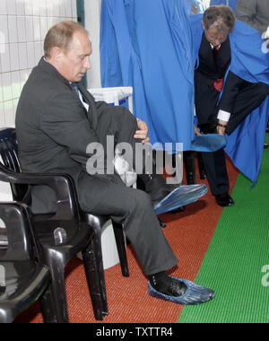 Le président russe Vladimir Poutine prend un chaussures de protection avant l'inspection d'une ferme dans petit village Italmaz 800 milles à l'est de Moscou le 21 juin 2006. Visites de fermes autour de Poutine ville de Perm pour discuter d'un moyen de croissance de la production agricole dans le pays. (Photo d'UPI/Anatoli Zhdanov) Banque D'Images