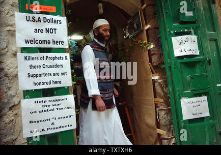 Un Palestinien quitte une boutique dans la vieille ville de Jérusalem avec un panneau disant 'USA Dollars ne sont pas les bienvenus ici," le 31 mars 2004. Des milliers de touristes ont annulé des plans pour visiter la Terre sainte lors de la Pâque et Pâques, craignant les attaques terroristes, depuis l'armée israélienne a assassiné chef du Hamas, cheikh Ahmed Yassine à Gaza la semaine dernière. (Photo d'UPI/Debbie Hill) Banque D'Images