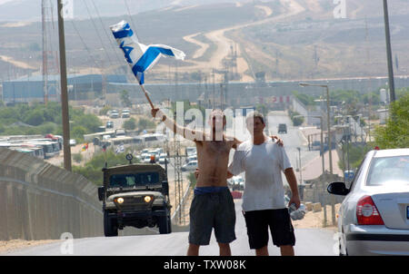 Des colons juifs, David et Evitar Haran de Nissanit arrêter leur voiture d'agiter le drapeau israélien qu'ils quittent la bande de Gaza, le 15 août 2005, près du poste de contrôle d'Erez. Les soldats israéliens ont donné un avis d'expulsion aujourd'hui, les colons de quitter la bande de Gaza avant le 17 août. (Photo d'UPI/Debbie Hill) Banque D'Images