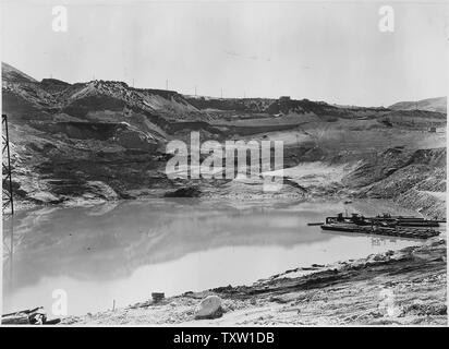 Une vue générale de la glisser sur la pente du bassin de l'est montrant pompes vidage monté sur des barges. Surface de l'eau dans la fosse à une altitude de 920. ; Portée et contenu : la photographie de deux volumes d'une série d'albums de photos documentant la construction du barrage de Grand Coulee et travaux connexes sur le bassin du Columbia Projet. Banque D'Images