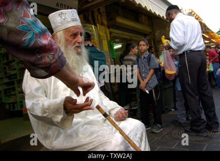 Une femme donne l'argent à un mendiant religieux dans le marché Mahane Yehuda à Jérusalem, le 20 septembre 2006, deux jours avant Roch Hachana, le Nouvel An juif, qui commence le vendredi au crépuscule. (Photo d'UPI/Debbie Hill) Banque D'Images