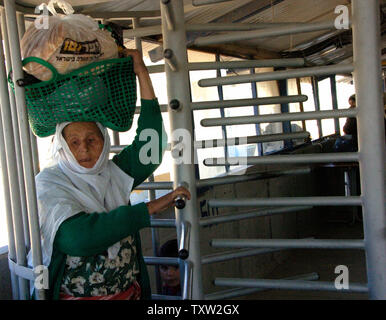 Une femme palestinienne promenades à travers un tourniquet après avoir passé un contrôle de sécurité par des soldats israéliens au poste de contrôle de Hawara, près de Naplouse en Cisjordanie sur Novembre 22, 2006. (Photo d'UPI/Debbie Hill) Banque D'Images