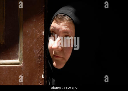 Une nonne orthodoxe grecque s'ouvre la porte sur le site d'une attaque dans la vieille ville de Jérusalem, le 10 août 2007. Un homme saisi un pistolet d'un garde de sécurité israéliennes et tiré sur lui, entraînant une fusillade dans laquelle l'assaillant a été tué et 10 blessés. (UPI Photo/ Debbie Hill) Banque D'Images