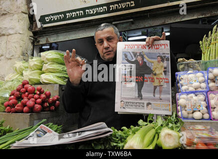 Un vendeur de légumes israélienne à Jérusalem donne un o.k. signer tout en tenant un journal israélien avec une photo de couverture du Président des Etats-Unis Barack Obama et son épouse Michelle le jour de l'investiture, le 21 janvier 2009. L'hébreu, sous le titre 'Good Morning America'. (Photo d'UPI/Debbie Hill) Banque D'Images