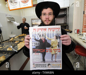 Un Israélien ultra-orthodoxes dans une boulangerie de Jérusalem est titulaire d'un journal israélien avec une photo de couverture du Président des Etats-Unis Barack Obama et son épouse Michelle, 21 janvier 2009. L'hébreu, sous le titre 'Good Morning America'. (Photo d'UPI/Debbie Hill) Banque D'Images