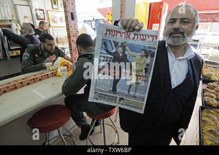 Un Israélien dans une boulangerie de Jérusalem est titulaire d'un journal israélien avec une photo de couverture du Président des Etats-Unis Barack Obama et son épouse Michelle le jour de l'investiture, le 21 janvier 2009. L'hébreu, sous le titre 'Good Morning America'. (Photo d'UPI/Debbie Hill) Banque D'Images