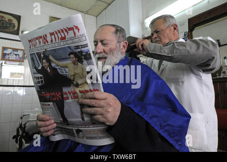 Une israélienne à Jérusalem un barbershop lit un journal israélien avec une photo de couverture du Président des Etats-Unis Barack Obama et son épouse Michelle le jour de l'investiture, le 21 janvier 2009. L'hébreu, sous le titre 'Good Morning America'. (Photo d'UPI/Debbie Hill) Banque D'Images