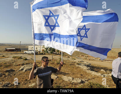 Un colon israélien vagues drapeaux israéliens dans la colonie illégale juive outpost Mitzpe Avigail en Cisjordanie, le 2 juin 2009. Le président des États-Unis, Barack Obama, chefs au Moyen-Orient cette semaine pour prononcer un discours au monde Musulman au Caire jeudi. Le gouvernement israélien fait fi de la demande américaine pour un gel complet de l'expansion des colonies en Cisjordanie. (Photo d'UPI/Debbie Hill) Banque D'Images