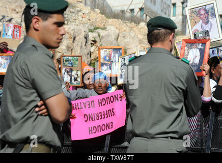 La police israélienne a stand by comme israéliens éthiopiens tenir des photographies de famille toujours en Éthiopie lors d'une manifestation devant le Premier ministre israélien Benjamin Netanyahu, à Jérusalem, le 10 janvier 2009. Les manifestants ont demandé au gouvernement de mettre fin à sa politique de discrimination à l'octroi de l'immigration de Juifs éthiopiens. Il y a quelques 8 700 Juifs éthiopiens attendent toujours d'émigrer en Israël . UPI/Debbie Hill Banque D'Images