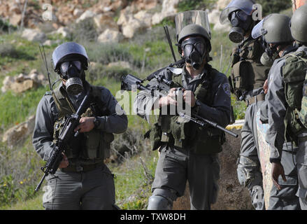 La police des frontières israélienne porter gasmasks avant de tirer des gaz lacrymogènes sur des manifestants palestiniens, pas connu, dans le village en Nabi Salih, le 12 février 2010. Les Palestiniens disent que la colonie israélienne Halamish prend leurs terres et l'eau. UPI/Debbie Hill Banque D'Images