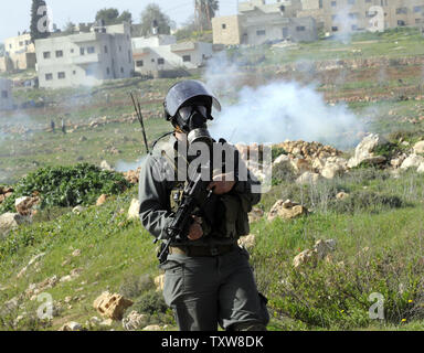 Une police des frontières israélienne porte un gasmask après avoir tiré des gaz lacrymogènes sur des manifestants palestiniens, pas connu, dans le village en Nabi Salih, le 12 février 2010. Les Palestiniens disent que la colonie israélienne Halamish prend leurs terres et l'eau. UPI/Debbie Hill Banque D'Images