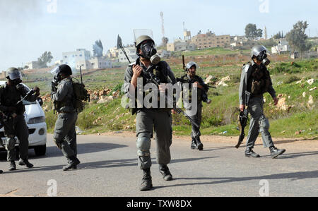 La police des frontières israélienne porter gasmasks après avoir tiré des gaz lacrymogènes sur des manifestants palestiniens, pas connu, dans le village en Nabi Salih, le 12 février 2010. Les Palestiniens disent que la colonie israélienne Halamish prend leurs terres et l'eau. UPI/Debbie Hill Banque D'Images