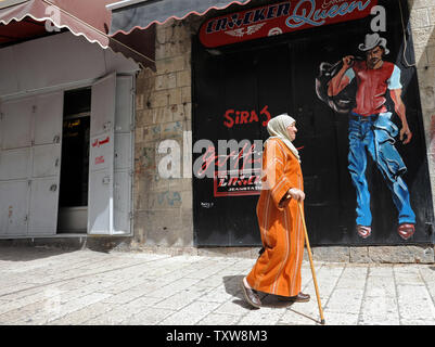 Une femme palestinienne passe devant une boutique de vêtements avec obturateur à Jérusalem-Est, près de la vieille ville, le 15 mars 2010. Des commerçants palestiniens ont fermé leurs boutiques pendant plusieurs heures pour protester contre la poursuite par Israël de la construction de maisons dans la Jérusalem-Est arabe. L'Ambassadeur d'Israël aux Etats-Unis, Michael Oren, a déclaré que les États-Unis et Israël face à leurs relations pire crise en 35 ans après qu'Israël a annoncé son intention d'élargir le quartier de Ramat Shlomo à Jérusalem-Est au cours de la visite du vice-président américain Joe Biden dans la région la semaine dernière. UPI/Debbie Hill Banque D'Images