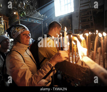 Pèlerins russes allumer des bougies dans l'église de la Nativité, où les chrétiens croient que Jésus Christ est né, à Bethléem, en Cisjordanie, le 14 décembre 2010. UPI/Debbie Hill Banque D'Images