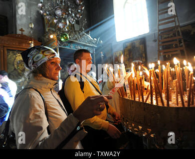 Pèlerins russes allumer des bougies dans l'église de la Nativité, où les chrétiens croient que Jésus Christ est né, à Bethléem, en Cisjordanie, le 14 décembre 2010. UPI/Debbie Hill Banque D'Images