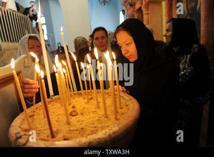 Une religieuse grecque orthodoxe prie à côté des bougies dans la grotte dans l'église de Saint-Nicolas à Beit Jala, près de Bethléem, en Cisjordanie, à la Saint-Nicolas, le 19 décembre 2010. La tradition considère que saint Nicolas a vécu dans la grotte sous l'église à partir de la 312-315 AD. Saint Nicolas est le saint patron de Beit Jala et que l'on croit être son défenseur et protecteur pendant les guerres et les temps de besoin. UPI/Debbie Hill Banque D'Images