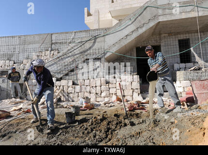 Les travailleurs de la construction palestinienne construire de nouveaux logements juifs dans la colonie Har Homa en Cisjordanie, le 28 décembre 2010. Plus de 35 000 travailleurs palestiniens sont employés bâtir de nouvelles maisons dans les colonies israéliennes en Cisjordanie. UPI/Debbie Hill Banque D'Images