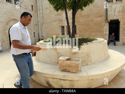 Un travailleur de l'Autorité des antiquités d'Israël porte un morceau de la couverture d'un ancien ossuaire 2 000 ans au musée Rockefeller à Jérusalem, le 29 juin 2011. Les universitaires israéliens, a déclaré mercredi qu'ils ont confirmé l'authenticité de l'ancien ossuaire portant le nom du grand prêtre Caïphe du Nouveau Testament. L'ossuaire porte une inscription avec le nom de 'Miriam fille de Yeshua, fils de Caïphe, prêtre de Maazia de Beth Imri.' Le grand prêtre Caïphe est célèbre pour son implication dans le procès et la crucifixion de Jésus Christ. UPI/Debbie Hill Banque D'Images