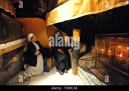 Une religieuse prie dans la grotte dans l'église de la Nativité, où la tradition croit que Jésus Christ est né, la veille de Noël dans la ville biblique de Bethléem, en Cisjordanie, le 24 décembre 2011. UPI/Debbie Hill Banque D'Images