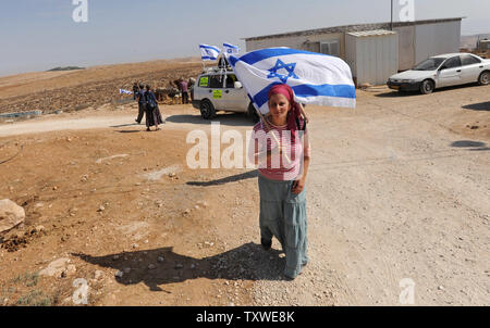 Un Israélien de droite porte le drapeau national lors d'une visite à l'avant-poste de colonisation juives illégales Mitzpe Yair, près d'Hébron, pour montrer leur soutien à l'expansion des colonies en Cisjordanie, le 19 octobre 2012. UPI/Debbie Hill Banque D'Images