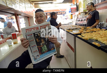 Un Israélien lit le journal hébreu Yediot Ahronot doté d''une photo du président américain Barack Obama et sa famille sur la couverture et se lit en hébreu 'Obama quatre ans de plus" dans un café à Jérusalem, Israël, le 8 novembre 2012. UPI/Debbie Hill Banque D'Images