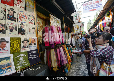 Un touriste prend une photo à l'extérieur d'une boutique de souvenirs sur la Via Dolorosa dans la vieille ville de Jérusalem amélioré numériquement la vente de t-shirts avec des photos du président américain Barack Obama comme un juif ultra-orthodoxes, Palestiniens et Oussama ben Laden, le 10 novembre 2012. Divers dirigeants du monde sont également indiqués, y compris le candidat républicain Mitt Romney. UPI/Debbie Hill Banque D'Images