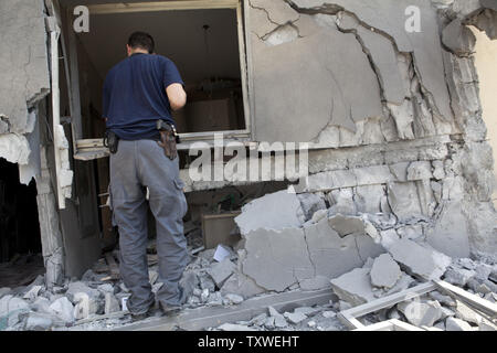 Un officier de police israélien examine les dommages causés à une maison directement touchées par une fusée dans la ville israélienne de Be'er Sheva par les forces du Hamas dans la bande de Gaza, le 20 novembre 2012. UPI/Mati Milstein Banque D'Images