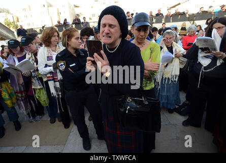 Une femme juive ultra-orthodoxes prie et pleure comme elle proteste contre les femmes portant des châles de prière et tefillin pendant un service de prière de rosh hodesh, qui marque le début du mois hébreu de Nisan, au Mur Occidental à Jérusalem, Israël, le 12 mars 2013. Plus d'une centaine de femmes a prié avec les femmes du mur comme les hommes ultra-orthodoxes a crié de l'autre côté de la clôture qui sépare les hommes et les femmes au Mur occidental. Les femmes du Mur demande que les droits des femmes à prier au Mur des Lamentations, lieu saint du judaïsme sans restrictions que le judaïsme orthodoxe interdit aux femmes Banque D'Images
