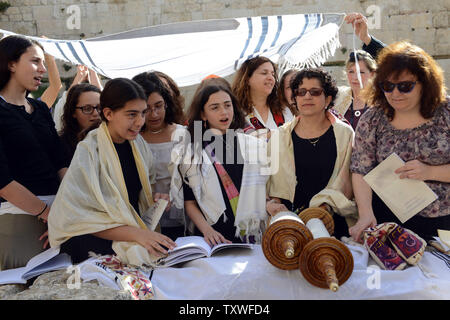 Les femmes portent des châles de prière juif tout en priant avec la Tora à un service de prière de rosh hodesh, qui marque le début du mois hébreu de Nisan, près du Mur Occidental à Jérusalem, Israël, le 12 mars 2013. Plus d'une centaine de femmes a prié avec les femmes du mur comme les hommes ultra-orthodoxes a crié de l'autre côté de la clôture qui sépare les hommes et les femmes au Mur occidental. Les femmes du Mur demande que les droits des femmes à prier au Mur des Lamentations, lieu saint du judaïsme sans restrictions que le judaïsme orthodoxe interdit aux femmes de porter des châles de prière et tefillin ou danser et chanter Banque D'Images