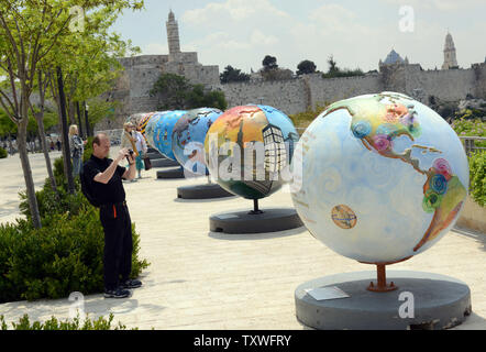 Un touriste prend une photo d'un globe, une partie de la Cool Globes Project, une exposition d'art publique internationale 18 globes surdimensionné conçu pour inspirer un appel à l'action environnementale, près de la porte de Jaffa, l'extérieur de la vieille ville de Jérusalem, Israël, le 19 avril 2013. Les globes, une initiative de l'organisme sans but lucratif basé à Chicago Cool Globes, vise à faire prendre conscience des changements climatiques. Les globes ont été portées à Jérusalem dans le cadre du premier Symposium international de Jérusalem sur vert et accessible qui a lieu de pèlerinage à Jérusalem cette semaine. UPI/Debbie Hill Banque D'Images