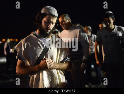 Un colon israélien prie devant une manifestation devant la prison d'Ofer, près de Jérusalem, à l'encontre de la prochaine libération de prisonniers palestiniens, le 28 octobre 2013. Israël est réglée pour libérer 26 prisonniers palestiniens qui ont mené des attaques terroristes contre les Israéliens. Les familles endeuillées de victimes assassinées ont publié des photos de leurs proches et a appelé le Premier ministre israélien Benjamin Netanyahu pour arrêter la libération de prisonniers. UPI/Debbie Hill Banque D'Images