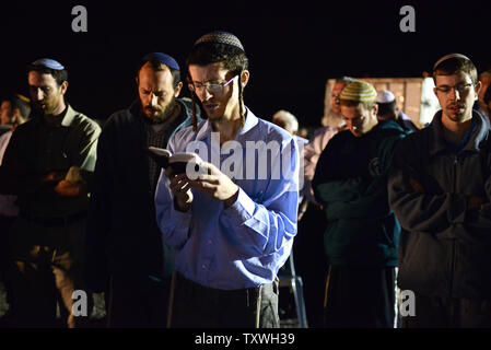 Les colons israéliens prient avant une manifestation devant la prison d'Ofer, près de Jérusalem, à l'encontre de la prochaine libération de prisonniers palestiniens, le 28 octobre 2013. Israël est réglée pour libérer 26 prisonniers palestiniens qui ont mené des attaques terroristes contre les Israéliens. Les familles endeuillées de victimes assassinées ont publié des photos de leurs proches et a appelé le Premier ministre israélien Benjamin Netanyahu pour arrêter la libération de prisonniers. UPI/Debbie Hill Banque D'Images